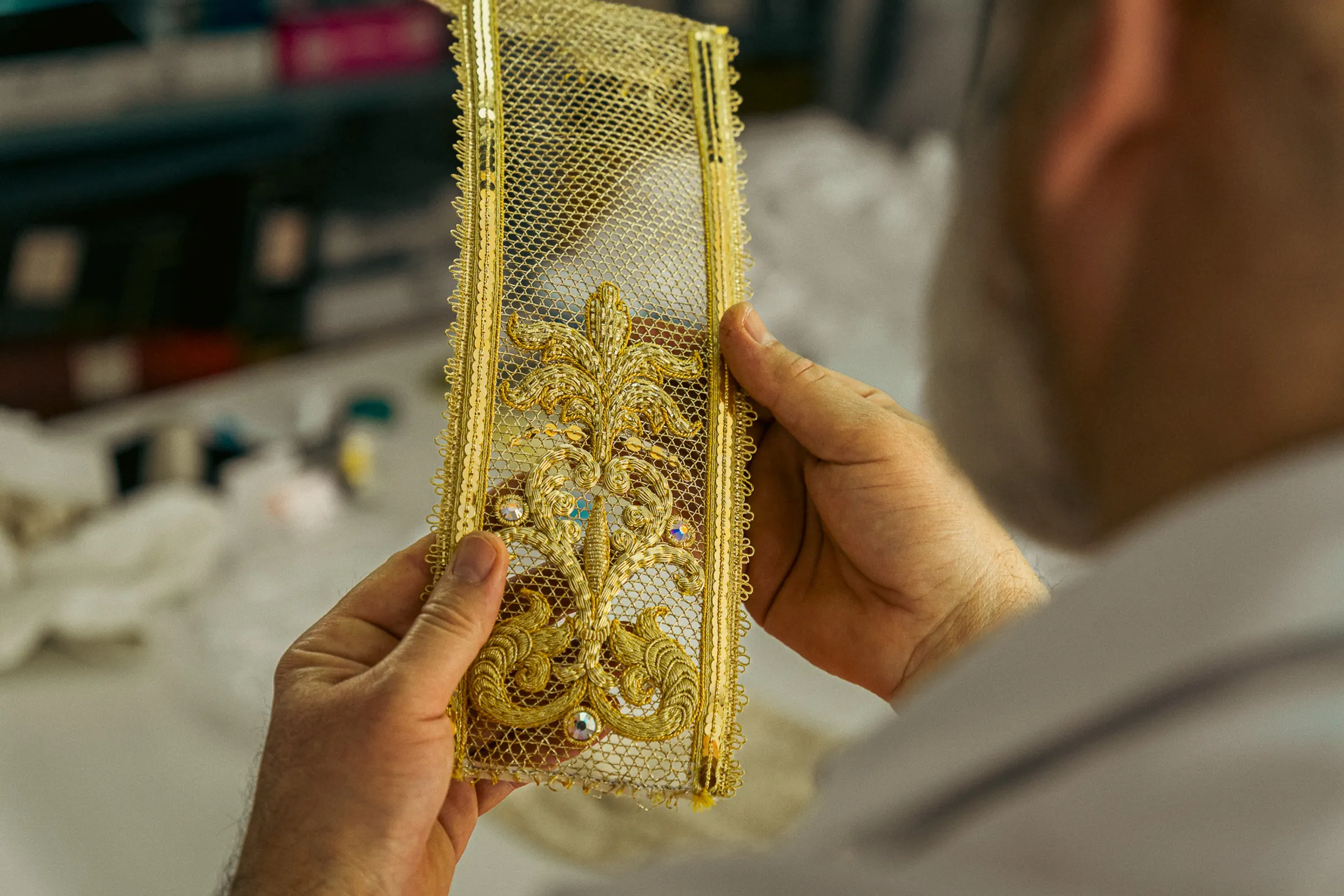 Gallone ricamato in oro tra le mani del maestro